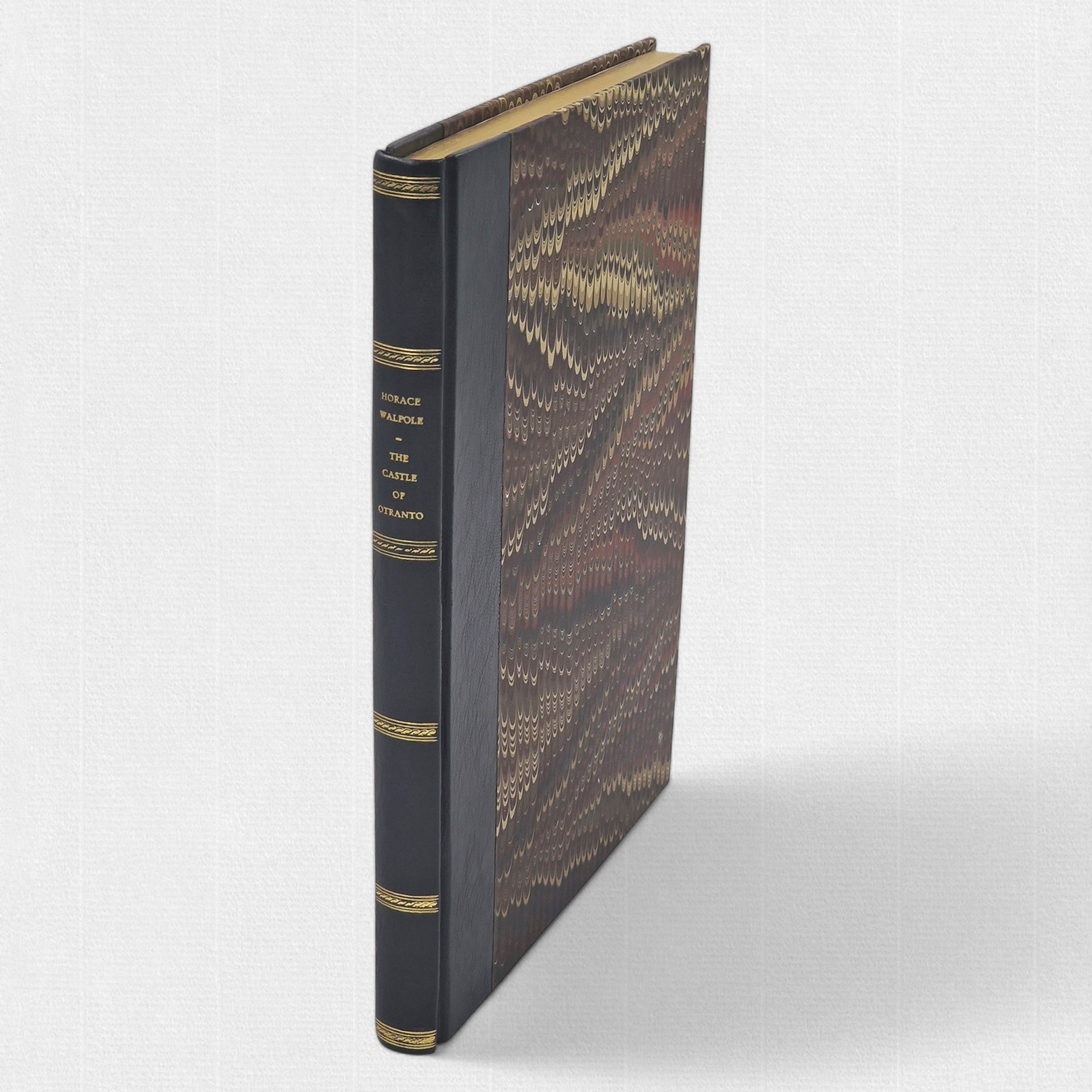 Front board of The Castle of Otranto showing hand-marbled paper sides and leather spine with gilt decoration.