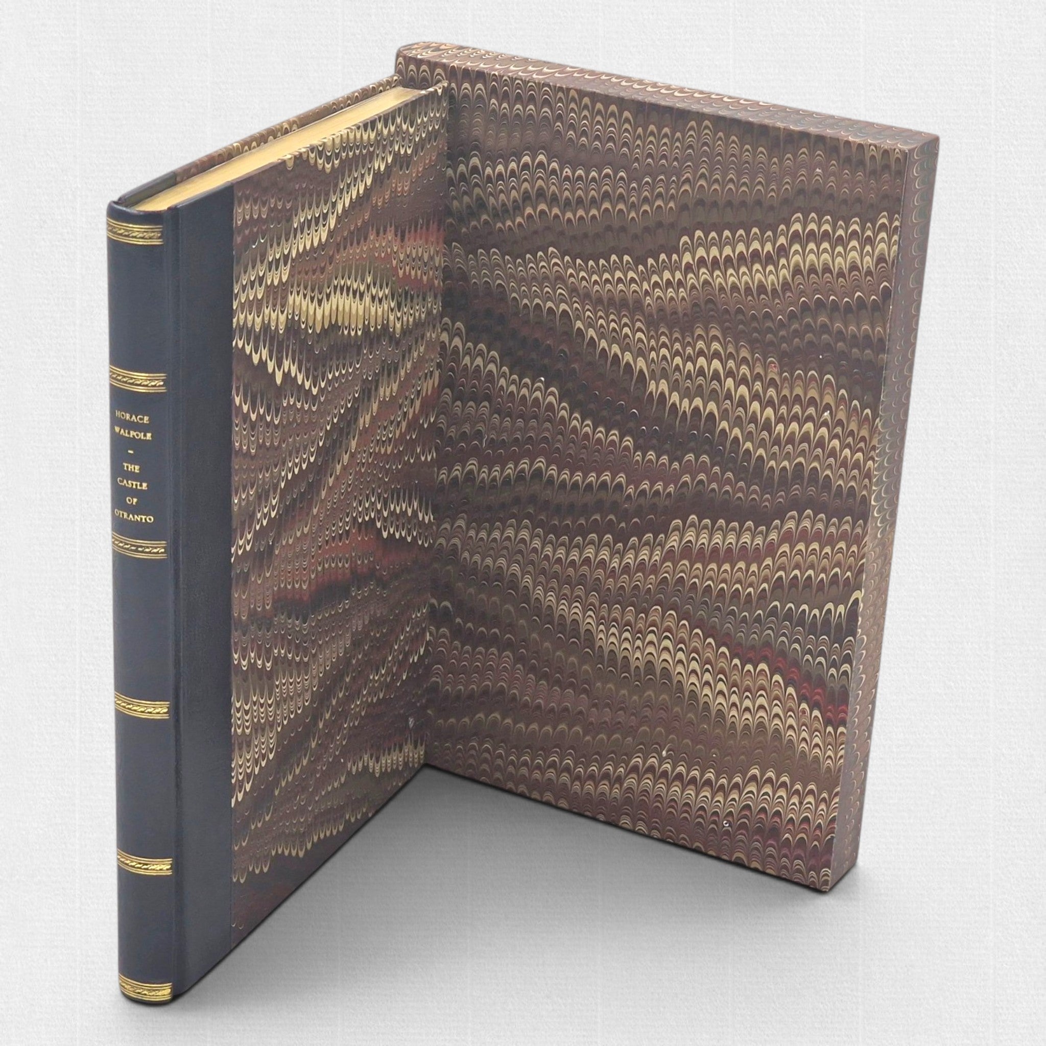 The Castle of Otranto fine press edition beside its open marbled slipcase, showing leather spine and decorative paper sides.