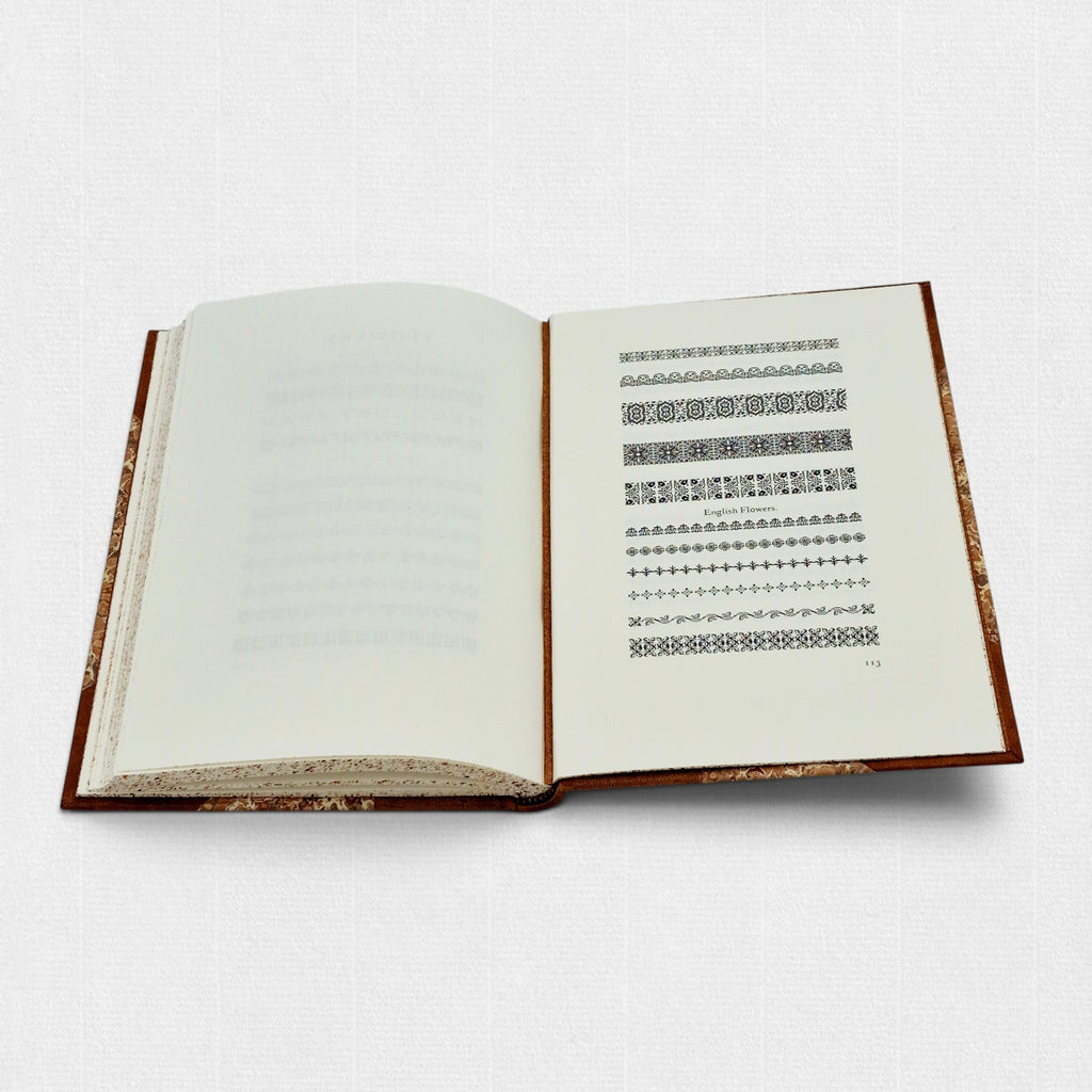 Interior spread of The Revival of Caslon Types showing specimen pages of Caslon printer’s ornaments and decorative flowers.