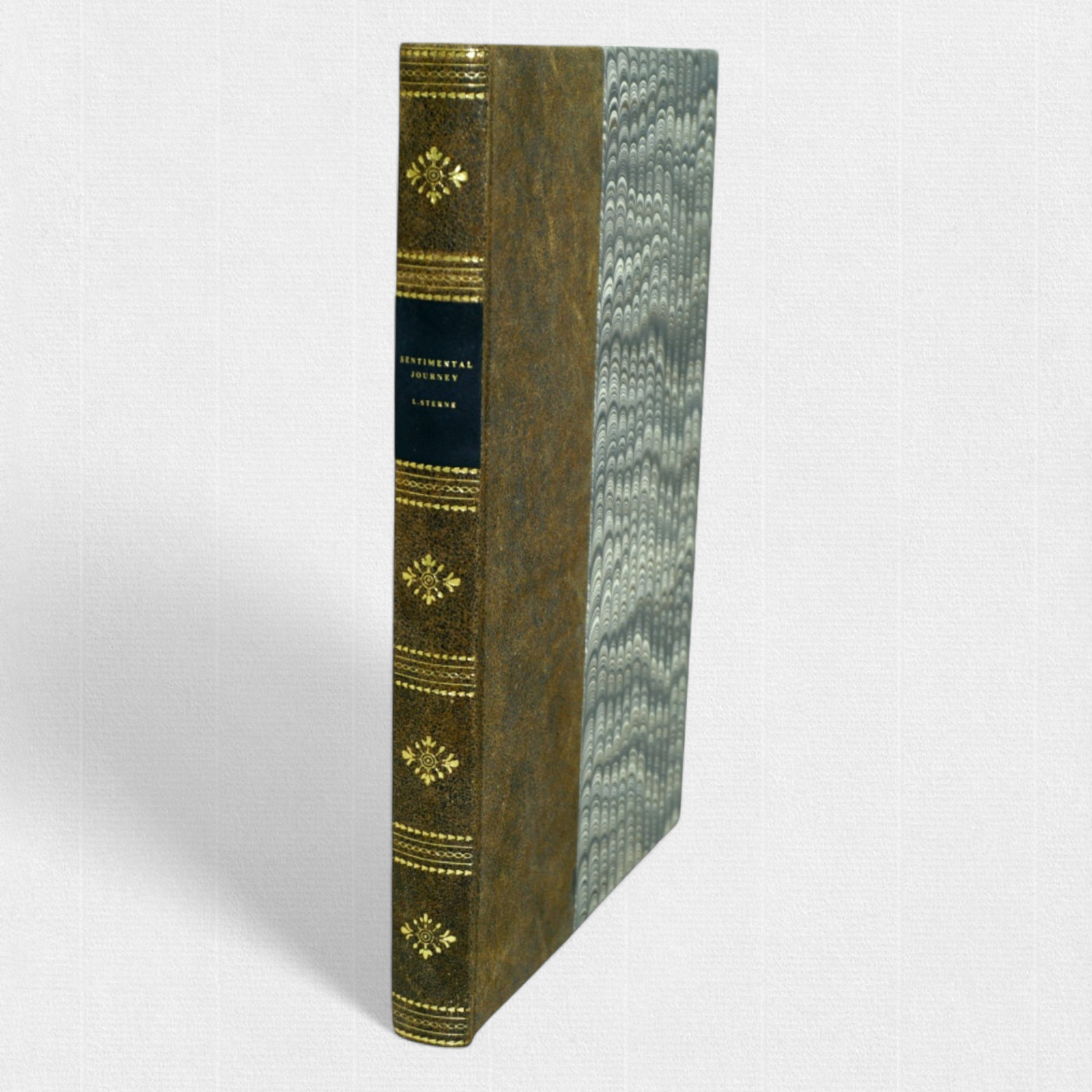 Hand-bound Woodbank Press edition of Laurence Sterne’s A Sentimental Journey, featuring half-leather binding, marbled boards, and gilt spine tooling.