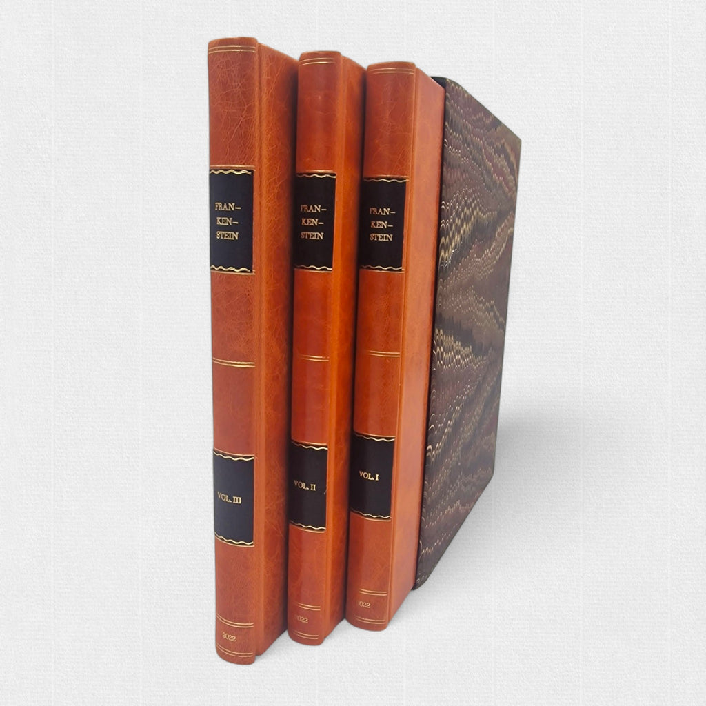 Spines of the three-volume Frankenstein fine press edition with gilt lettering and marbled slipcase.